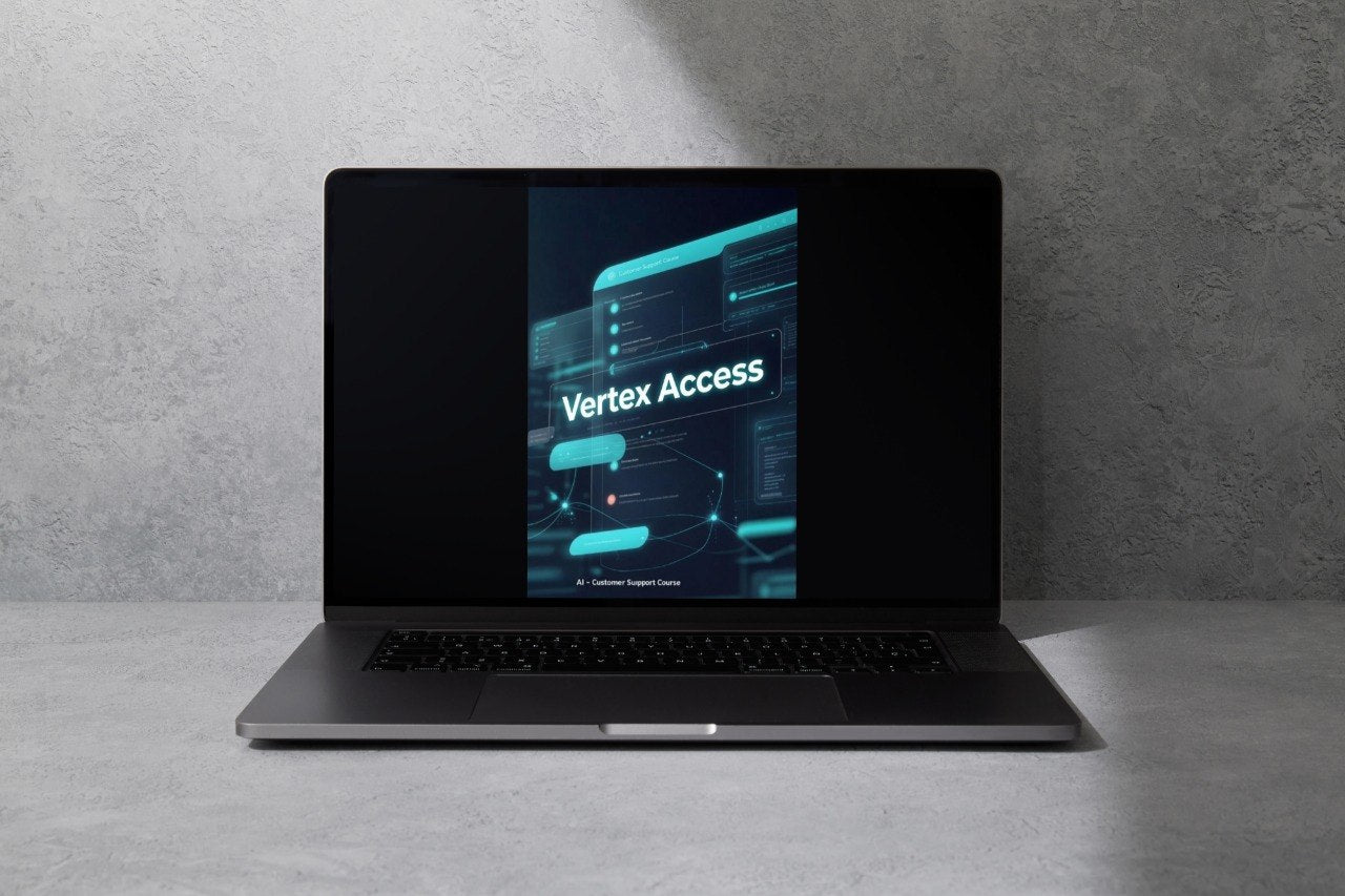 A dark gray laptop sits open on a light gray surface against a textured gray wall, with its screen displaying a digital graphic that reads 'Vibe System'.